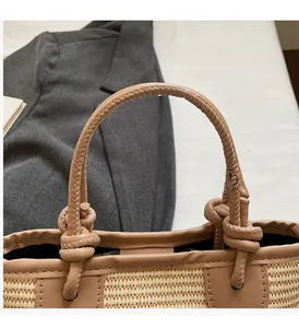 Macro detail of hand-woven straw bag featuring a stylish knotted tan leather handle