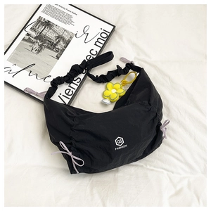 Black nylon crescent bag with ruffled strap, flower pendant, and QS FASHION logo