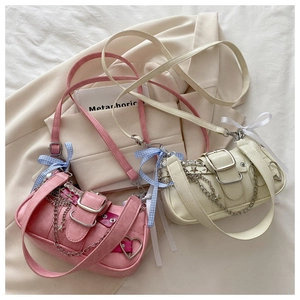 Detailed view of pink and beige Y2K handbags with metal stars and ribbon bows
