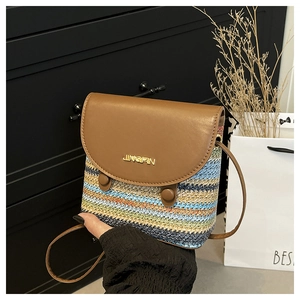 Détail du sac en paille à rayures multicolores avec rabat en cuir brun et logo en métal