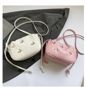 Detail of white and pink butterfly PU leather crossbody bags with silver metal ornaments