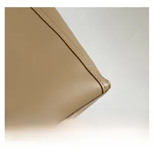 Macro shot of khaki leather tote bag showing fine grain texture and neat stitching details