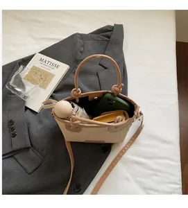 Detail view of woven straw bucket bag interior capacity with leather straps and accessories