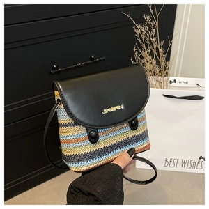 Détail du sac en paille tissé à rayures colorées avec rabat en cuir noir et logo doré