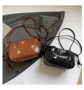 Detail of drawstring bags in black and brown with golden butterfly metallic buckles