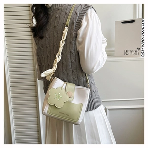 Détail du sac à main bicolore avec breloque florale et poignée en foulard en soie