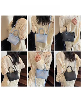 Detail of woven bucket bag with fashion label showing blue and black crossbody styles