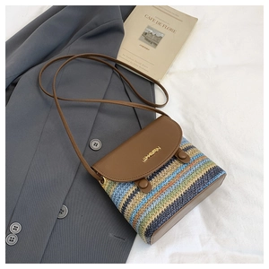 Détail d'un sac en paille tressée à rayures colorées avec un rabat en cuir marron premium