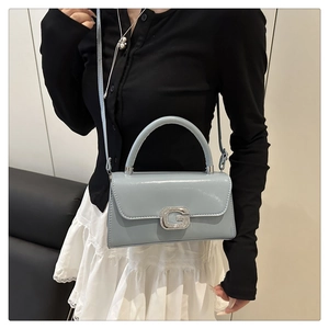Detailansicht der hellblauen Lackhandtasche mit glitzernder G-Schnalle und Umhängeriemen