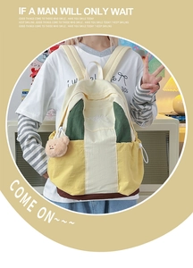 Detail of multi-color nylon backpack with bear pendant and DUOMAN BAG embroidery