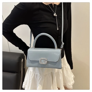 Detail der hellblauen Lackledertasche mit silberner G-förmiger Strass-Schnalle Verzierung
