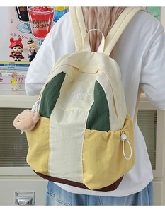 Detail of multi-color nylon backpack with bear charm and drawstring side pocket