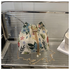 Détail du sac seau floral vintage avec chaîne dorée et finitions en perles