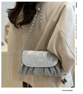 Silver pleated shoulder bag with metal chain strap and white plush doll charm