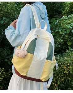 Detail of color-block nylon backpack with OUOMAN BAG embroidery and bear charm decoration