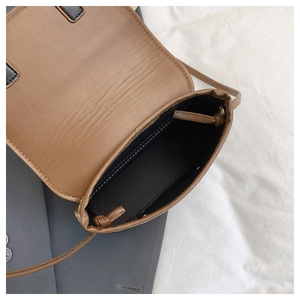 Detail shot of the interior lining and brown leather texture of the woven shoulder bag