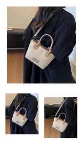 Detailed view of woven straw beach bag with khaki leather trim and fashion label