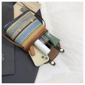 Détail intérieur du sac seau tissé à rayures montrant l'espace pour téléphone et cosmétiques