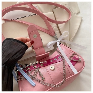 Détail d'un sac rose en similicuir avec breloques étoiles et chaînes métalliques