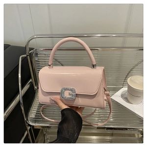 Detail der glänzenden rosa Handtasche mit einer funkelnden G-Schnalle mit Strasssteinen