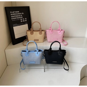 Detailed view of woven bucket bags in khaki, pink, blue, and black with detachable straps