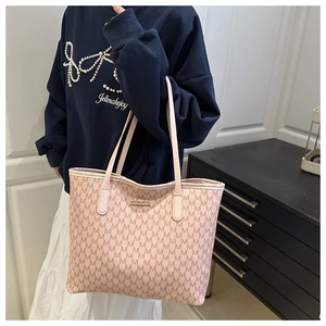 Vue détaillée d'un cabas rose à monogramme avec logo doré et grande capacité de rangement