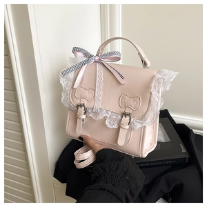 Dettaglio della borsa squadrata in PU rosa con pizzo bianco e decoro a fiocco