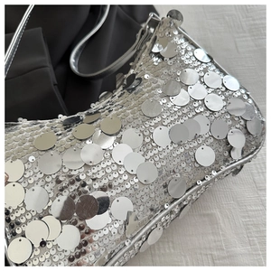 Dettaglio macro della trama di paillettes argentate su una borsa a mano da festa