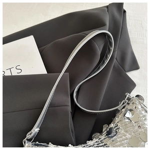 Dettaglio ravvicinato di paillettes argentate e tracolla in pelle della borsa moda