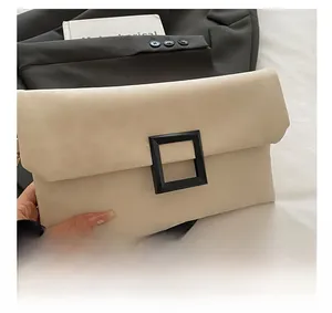Detail of minimalist beige leather handbag with large black square decorative buckle