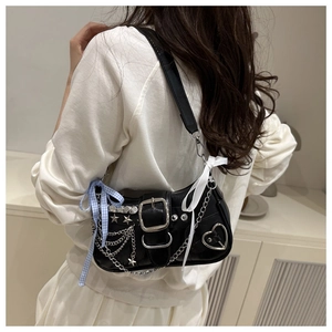 Détail du sac épaule Y2K noir avec rivets étoiles, chaînes et nœuds bleus stylés