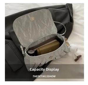 Capacity display of light grey pleated chain bag showing storage space for daily items