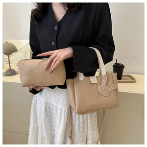 Detail of minimalist bucket bag set with fashion label and cute rabbit charm pendant