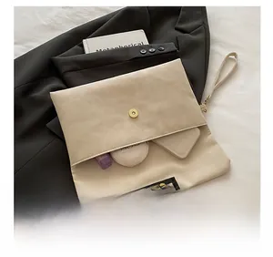 Interior capacity detail showing cosmetics inside a beige faux leather envelope bag