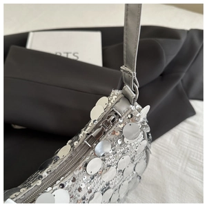 Dettaglio ravvicinato di paillettes argento e cerniera in metallo sulla borsa alla moda
