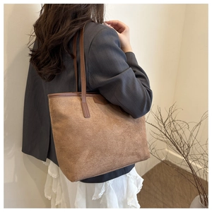 Model wearing a large vintage brown suede tote bag with leather straps for daily commute