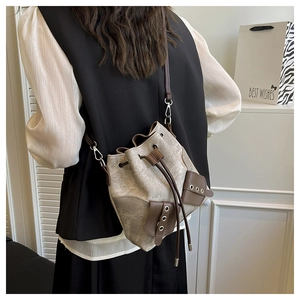 Close-up detail of vintage bucket bag with dual front pockets and drawstring closure