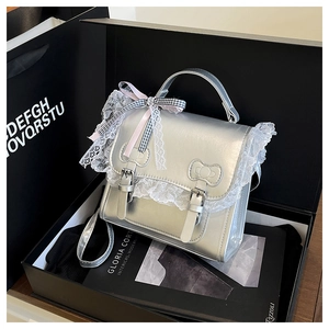 Borsa in pelle metallizzata argento con pizzo e nastri in una confezione regalo