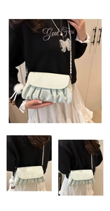 Detail of light green pleated cloud bag featuring silver chain and plush charm