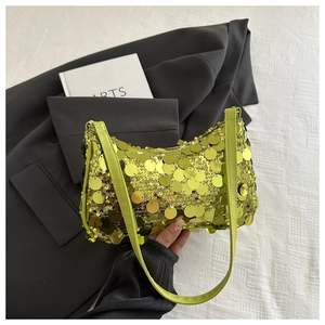 Dettaglio di una borsa sottobraccio con paillettes verde lime e riflessi luminosi