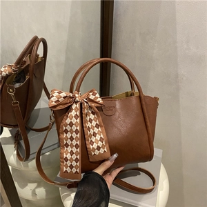 Retro dark brown bucket bag with silk scarf detail and adjustable shoulder strap