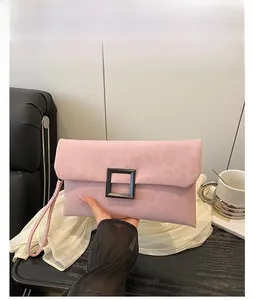 Pink suede-textured envelope clutch with matte black square buckle and wristlet strap