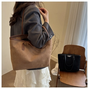 Detail showing high-capacity vintage tote bags in brown suede and black leather