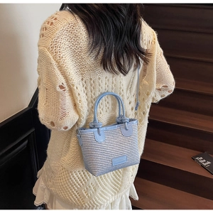 Detail of blue and white woven mini handbag with leather trim and crossbody strap