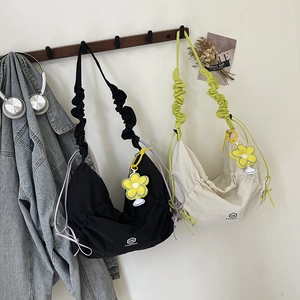 Fashionable nylon crescent hobo bags in black and beige with pleated straps and floral charm