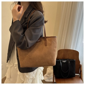 Detail of vintage brown suede tote bag featuring slim shoulder straps and branded hangtag