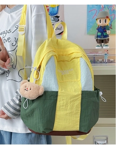 Close-up of contrast nylon backpack featuring brand embroidery and cute bear plush charm