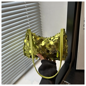 Detail van de textuur van een groene crossbodytas met pailletten en metallic glans
