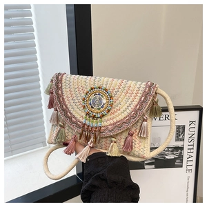 Detailed view of handmade woven envelope bag with colorful fringe and ethnic embroidery