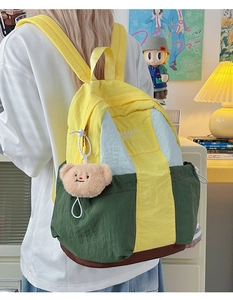 Detail of color-block nylon backpack with Roman Bag print and cute bear pendant